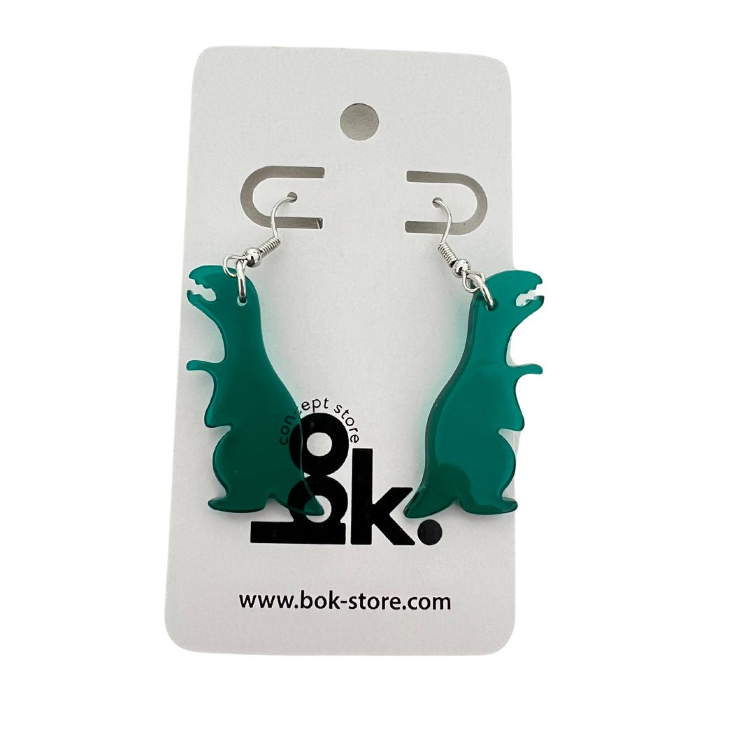 Aretes Freak en forma de dinosaurios verdes de acrílico. Un accesorio divertido y original, perfecto para los amantes de los dinos y la moda única.