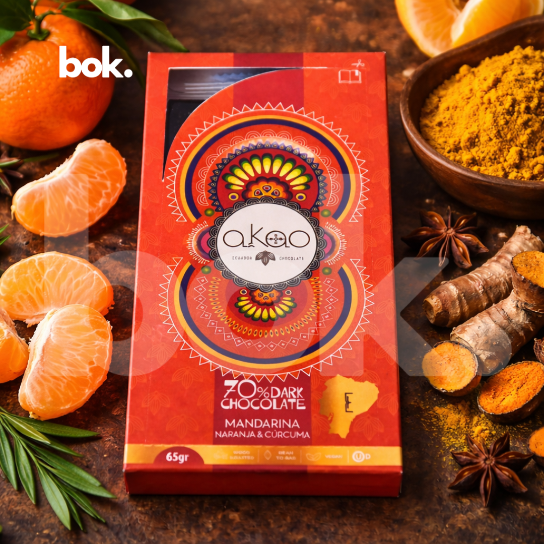 Chocolate dark 70% con mandarina, naranja y cúrcuma, empaque premium de diseño artístico en escena lifestyle sofisticada, chocolate ecuatoriano cálido y cítrico, curado por BOK Concept Store