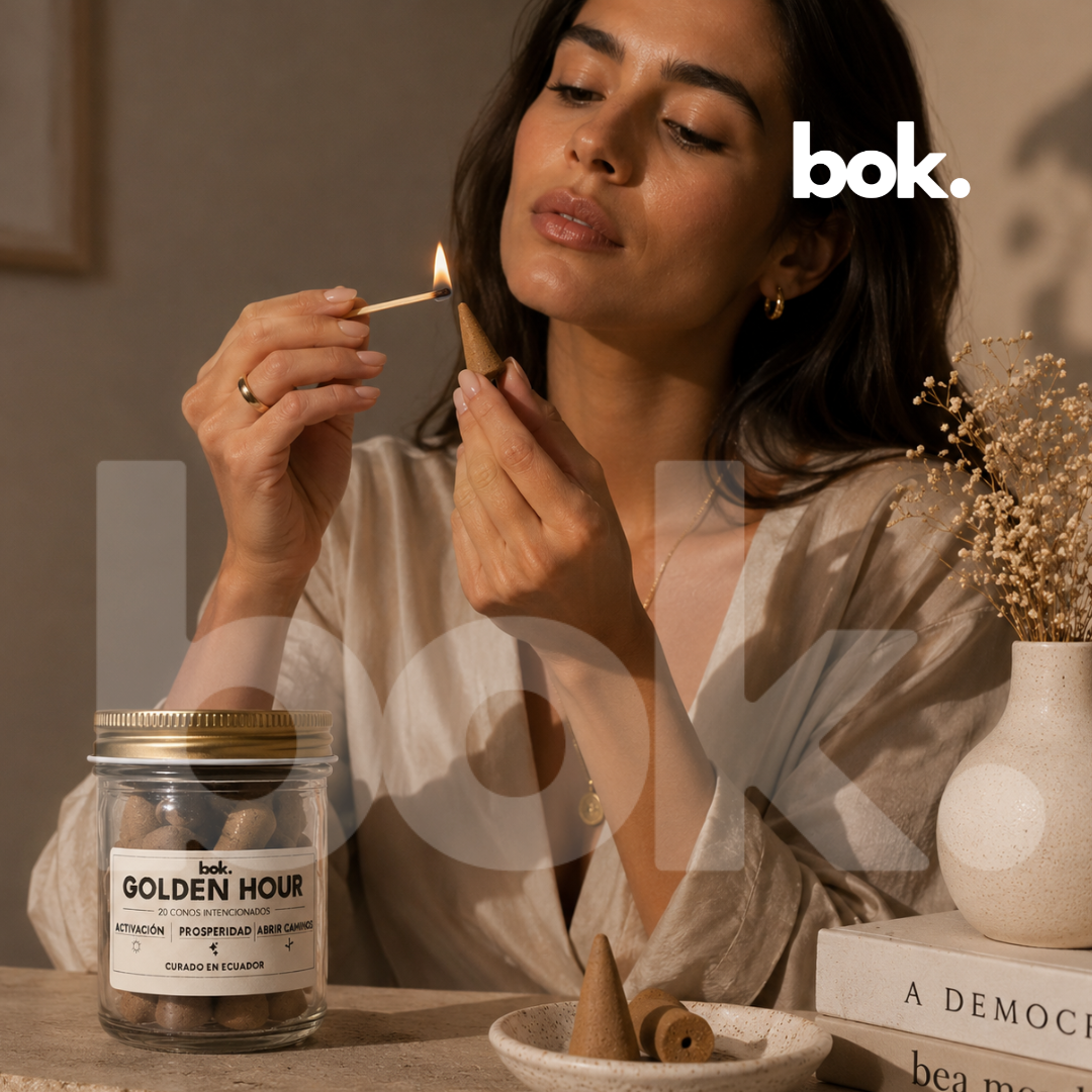 Mujer encendiendo conos intencionados backflow GOLDEN HOUR de BOK Concept Store Ecuador, ritual aromático premium de activación, abundancia y luxury wellness lifestyle
