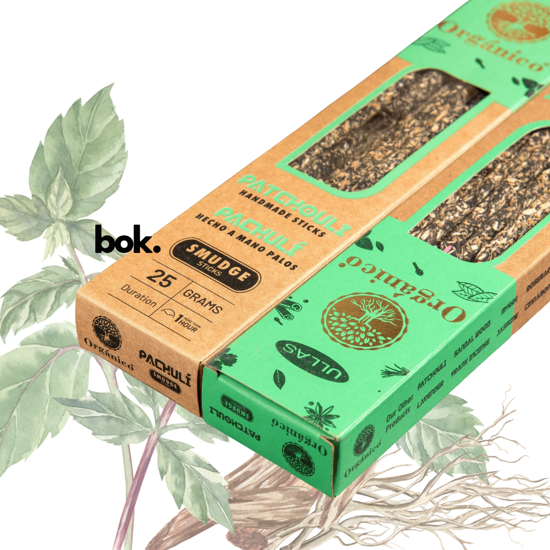 Incienso Patchouli artesanal BOK, caja color marrón-terracota de 25 gramos hecha a mano en la India, sostenida por una mano sobre fondo neutro, producto natural para meditación y bienestar.