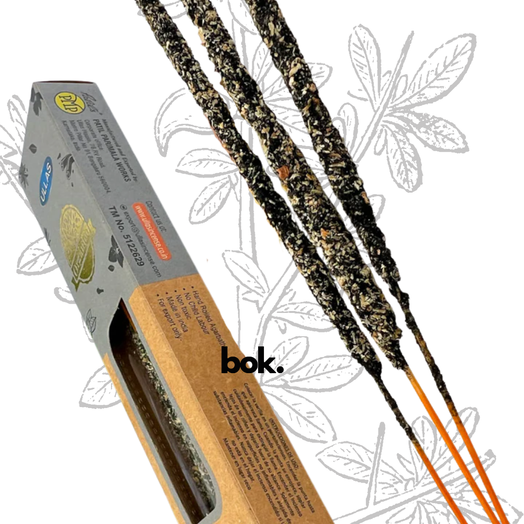 Incienso Yagra artesanal BOK, caja colorida de 25 gramos hecha a mano en la India, sostenida por una mano sobre fondo neutro, producto natural para meditación y bienestar.