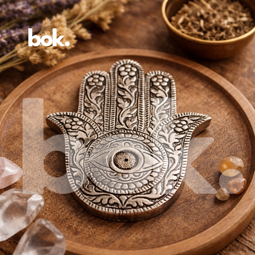 porta inciensos plateado en forma de mano hamsa con ojo protector y grabados artesanales de BOK Concept Store, sobre bandeja de madera en ambiente cálido y elegante con estética espiritual chic