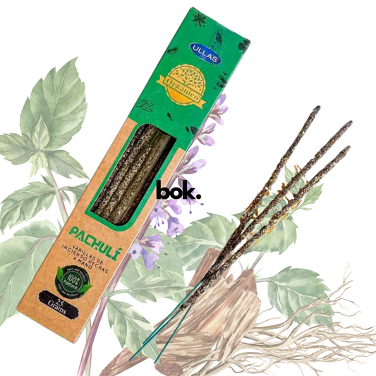 Incienso Patchouli artesanal BOK, caja color marrón-terracota de 25 gramos hecha a mano en la India, sostenida por una mano sobre fondo neutro, producto natural para meditación y bienestar.