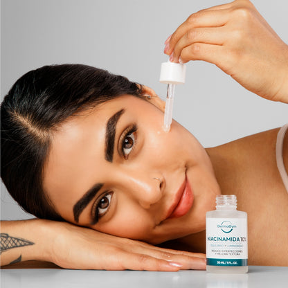 Modelo aplicando Niacinamida 10% DermaGym en el rostro, demostrando su uso; producto disponible en BOK Concept Store para equilibrar e iluminar la piel.