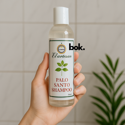 Botella de Shampoo de Palo Santo artesanal sostenida en la mano, producto natural ecuatoriano para el cuidado capilar, BOK Concept Store.