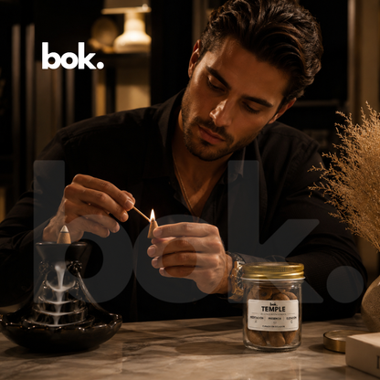 Hombre elegante encendiendo conos intencionados TEMPLE de BOK Concept Store Ecuador para crear una atmósfera de meditación, relajación profunda y conexión interior con estética luxury lifestyle premium