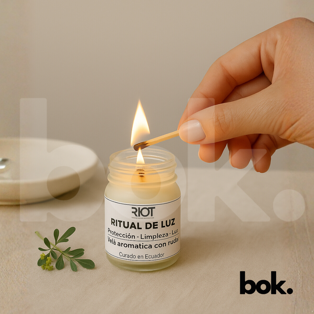  Ritual de Luz de, con etiqueta visible y una pequeña ramita de ruda dentro. Luz cálida natural, fondo minimalista y escena que transmite calma y energía positiva.