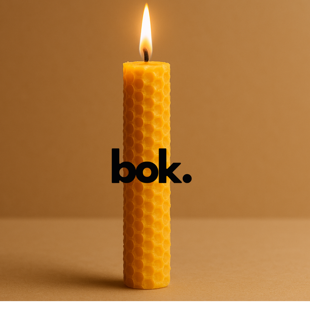 Vela artesanal de cera de abeja encendida con textura de panal, hecha a mano en Ecuador por BOK Concept Store, ideal para rituales y meditación.